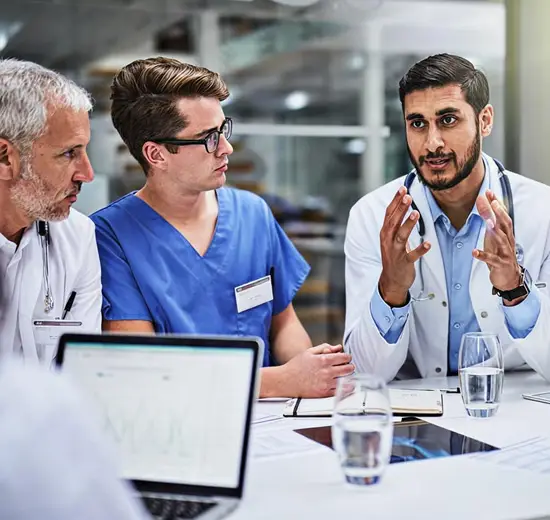 Team of doctors and healthcare professionals discussing patient care strategy during a medical meeting.