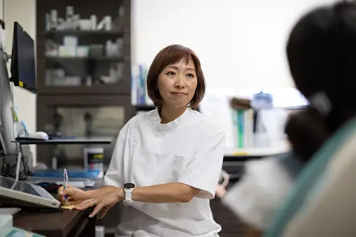 Pharmacist in white coat consulting with a patient at the pharmacy counter