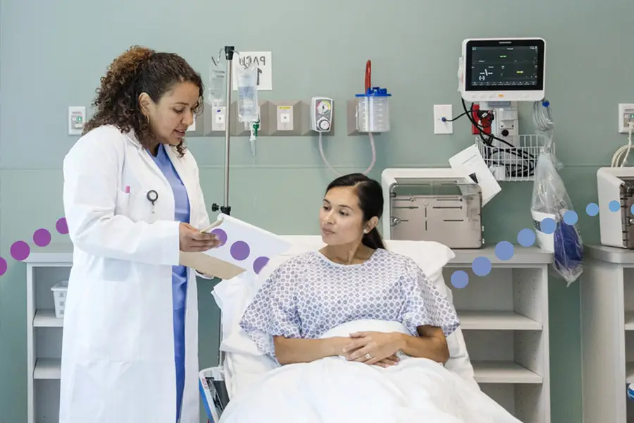 Doctor reviewing medical chart with patient in hospital bed