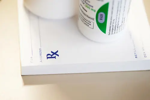 Prescription pad with medication bottles on top.