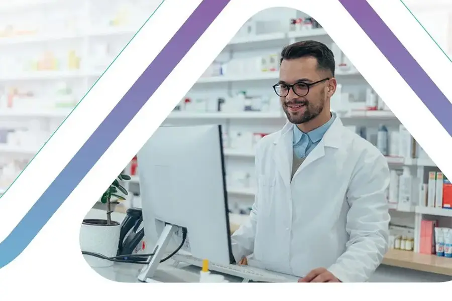 Pharmacist in white coat working on computer at modern pharmacy counter