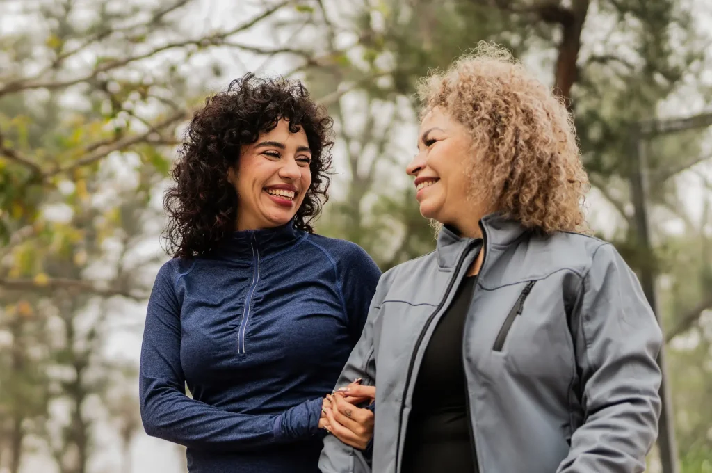 Mother and daughter talking while walking through the public park