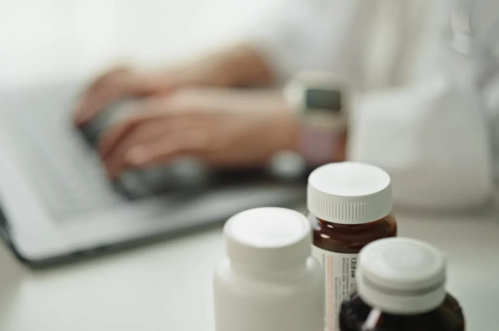 Close-up hand of doctor checking data on medicine pill.