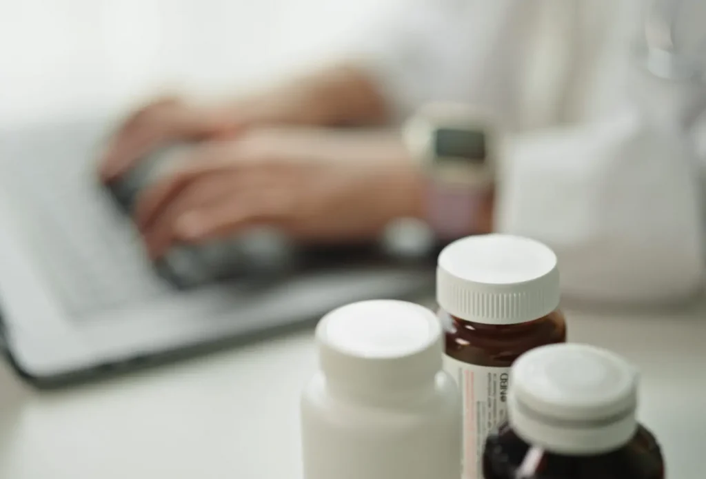 Close-up hand of doctor checking data on medicine pill.